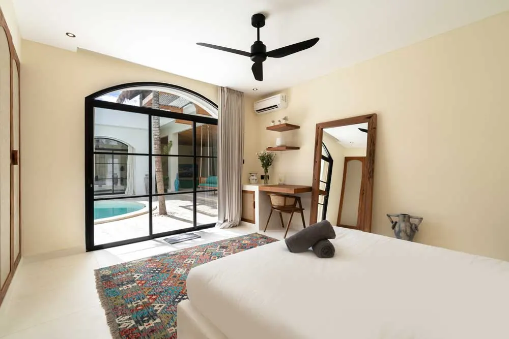 Zimmer mit Rundbogenfenster und Poolblick